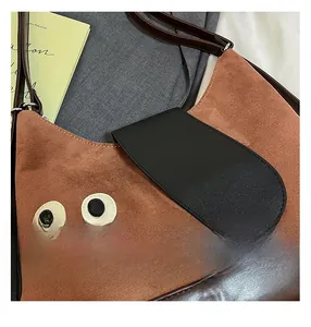 Dettaglio della borsa tote a forma di gatto con texture in camoscio e base in pelle