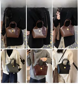 Mannequin portant un sac seau rétro en cuir avec foulard en soie et fermoir doré