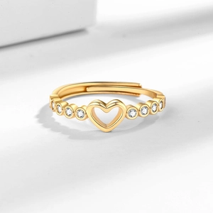 Bague cœur dorée ajustable avec pierres en zircone cubique sur fond minimaliste