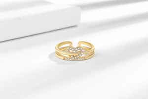 Detail shot of a double-layered gold heart ring with pavé-set zircons on white cubes