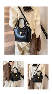 Détail du sac à main noir avec fermoir doré logo et foulard en soie à pois élégant