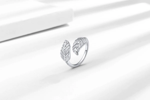Macro shot of silver feather ring showing fine engraved textures and adjustable band detail