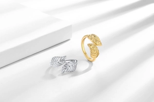 Detailed view of leaf rings in gold and silver finish with textured veins and open design