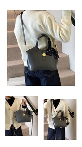 Détail du sac cabas gris foncé avec boucle dorée et foulard à pois sur l'anse
