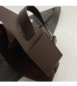 Detail shot of handcrafted stitching on dark brown matte leather bucket handbag