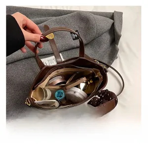Vue détaillée de l'intérieur du sac seau marron avec compartiments cosmétiques