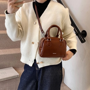 Dark brown patent leather bowling bag with silver hardware and shoulder strap