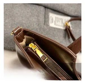 Détail de la fermeture éclair dorée et doublure sur le sac à main en cuir marron