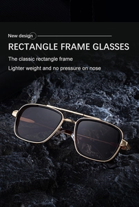 Détail de lunettes de soleil en métal doré avec double pont sur fond de pierre volcanique