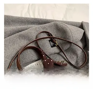 Gros plan du sac en cuir marron avec foulard à pois et garnitures dorées vintage