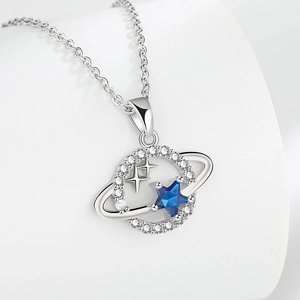 Deep blue planet necklace with sapphire blue star and silver accents on white stand