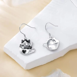 Asymmetric silver cat and heart teacup earrings with black enamel on a stone base