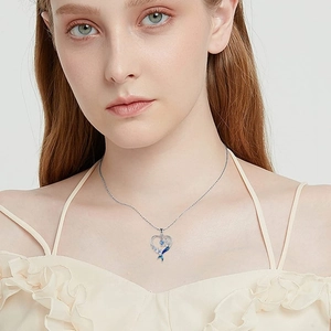 Blue mermaid tail heart necklace with silver chain shown on model in studio setting