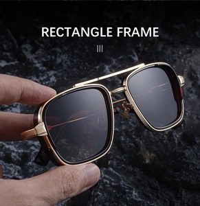 Gros plan détaillé de lunettes de soleil rectangulaires avec double pont doré sur roche