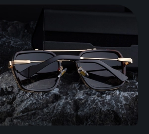 Detail of square pilot sunglasses with gold double bridge on black stone base
