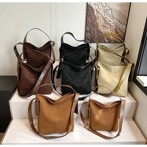 Detailed arrangement of minimalist suede bucket bags in assorted chic autumn colors