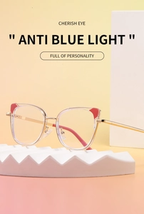 Detail of cat-eye anti-blue light glasses with red ear accents on a white display stand