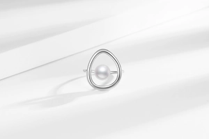 Macro detail of the round freshwater pearl in an irregular geometric silver frame