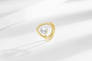 Close-up of irregular gold pearl ring featuring an organic geometric minimalist design