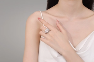 Dettaglio dell'anello a margherita rotante con petali in smalto e perla sulla mano