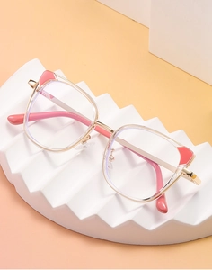 Detail view of champagne gold cat-ear glasses frame with pink transparent details