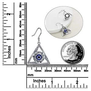 Gothic silver evil eye earrings with blue stones next to a measuring ruler and coin