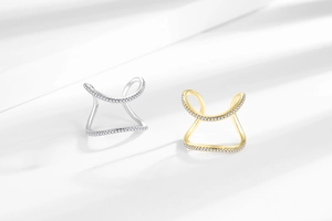 Detail of silver and gold-tone curved ear cuffs with pavé-set sparkling zircons