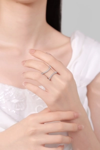 Detail of a double-row pavé diamond curve ring on model wearing a white lace dress