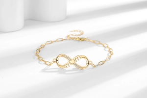 Détail du bracelet MOM infini doré avec élément de cœur et oxydes de zirconium brillants