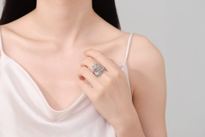 Close-up of a silver shooting star ring with blue and white zircons on a model hand