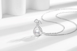 Macro detail of silver lucky pouch pendant with white pearl and micro-pave crystals