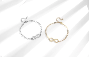 Détail des bracelets MOM infini en argent et or avec cristaux sur fond blanc épuré
