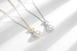 Detail of freshwater pearl pendants with bowknot and crystals on gold and silver chains