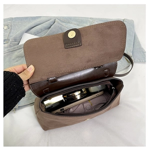 Vue détaillée de l'intérieur du sac en daim marron avec espace pour téléphone et maquillage