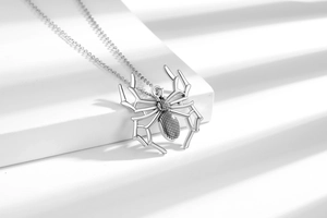 Macro detail of a silver spider pendant with black micro-inlays and geometric legs