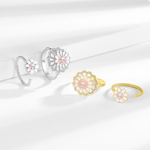 Anelli rotanti a margherita con smalto rosa e perle su gradini bianchi