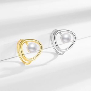 Minimalist geometric rings with white pearl in gold and silver finish on white platform