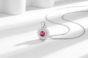 Gros plan du pendentif tournesol avec pierre centrale rouge et cristaux de zircon blanc