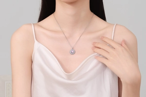 Détail d'un collier pendentif fleur avec zircon rose sur le cou d'un mannequin