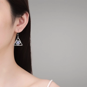 Gothic silver triangle Evil Eye drop earrings for women with blue eyeball detail