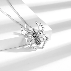 Silver spider pendant necklace in punk gothic style displayed on a minimalist white block