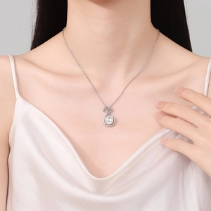 Elegant silver necklace featuring a round freshwater pearl pendant on a model wearer