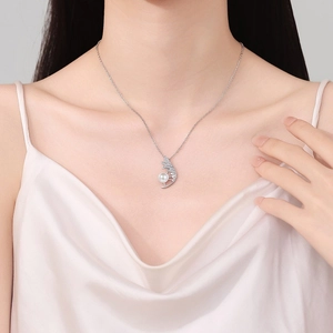 Elegant silver feather necklace with pearl pendant on model in soft lighting