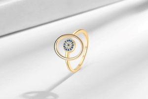Macro detail of gold evil eye ring with blue and white zircon micro-paving stones