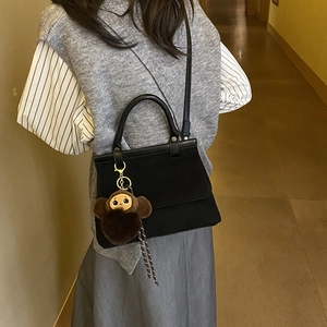Petit sac carré en cuir noir avec pendentif singe en peluche et bandoulière élégante