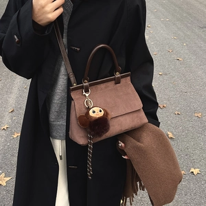 Sac carré en daim marron avec poignées en cuir et breloque singe en peluche pour l'hiver