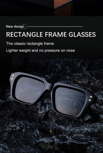 Detail of square black polarized sunglasses on a rock, showing rivets and sleek frame texture