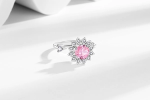 Gros plan sur une bague réglable en forme de fleur avec cristal rose et pavé de diamants