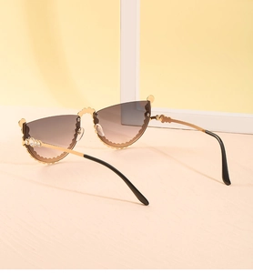 Détail de lunettes œil-de-chat sans monture avec bords festonnés dorés et cristaux