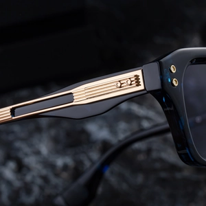 Detailed close-up of blue translucent temples with gold linear metal textures on sunglasses